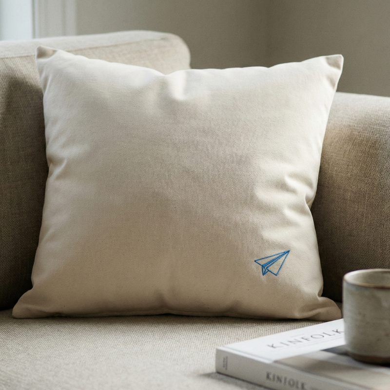 coussin en coton lavé fairtrade posé sur un canapé en lin dans une ambiance douce représentant les noces de papier