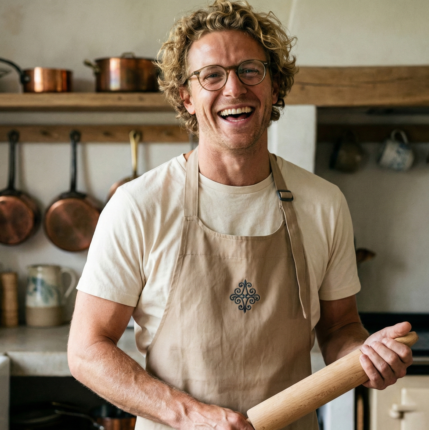 homme souriant dans une cuisine tenant un rouleau à patisserie et portant un tablier de cuisine célébrant les noces de fer