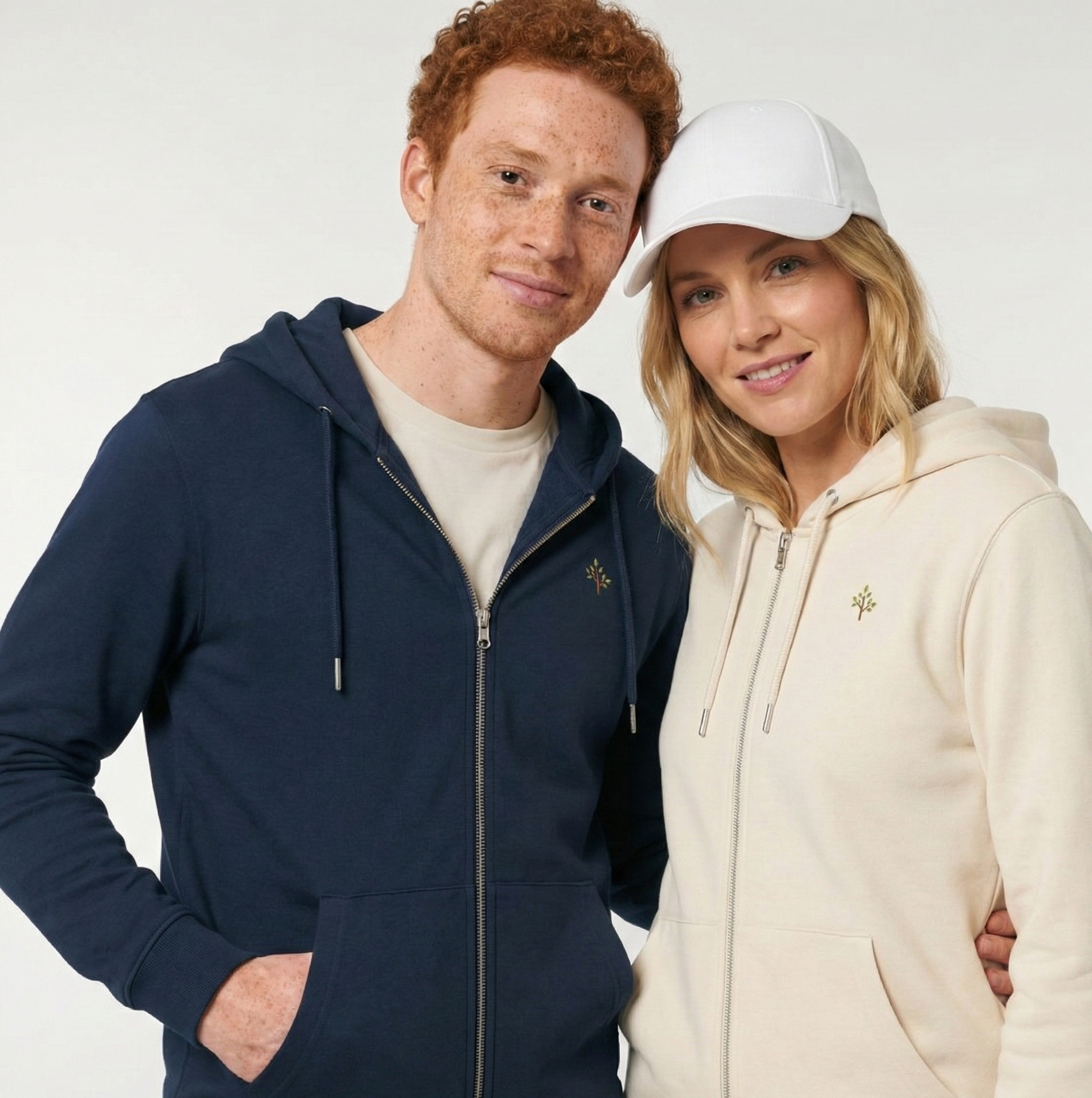 un homme et une femme portent un hoodie zippé unisexe floqué avec un logo représentant les noces de bois