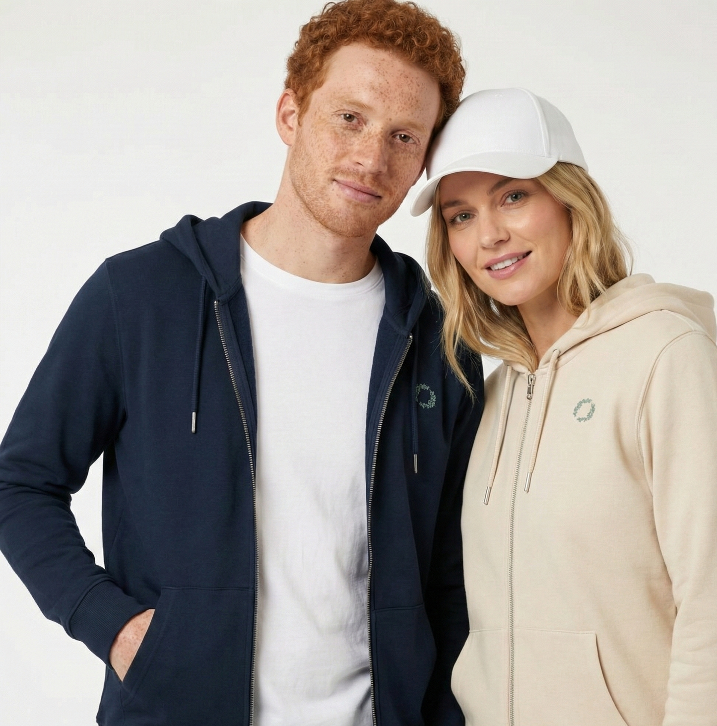 un homme et une femme portent un hoodie zippé unisexe floqué avec un logo représentant les noces de fleur