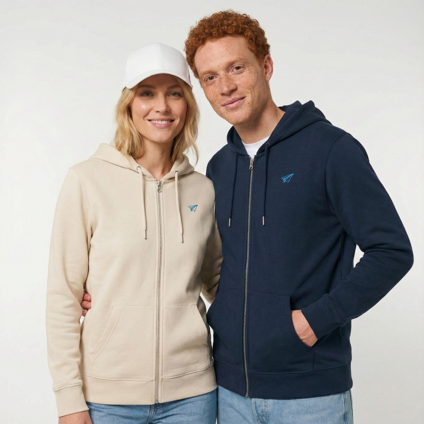 un homme et une femme portent un hoodie zippé unisexe floqué avec un logo représentant les noces de papier