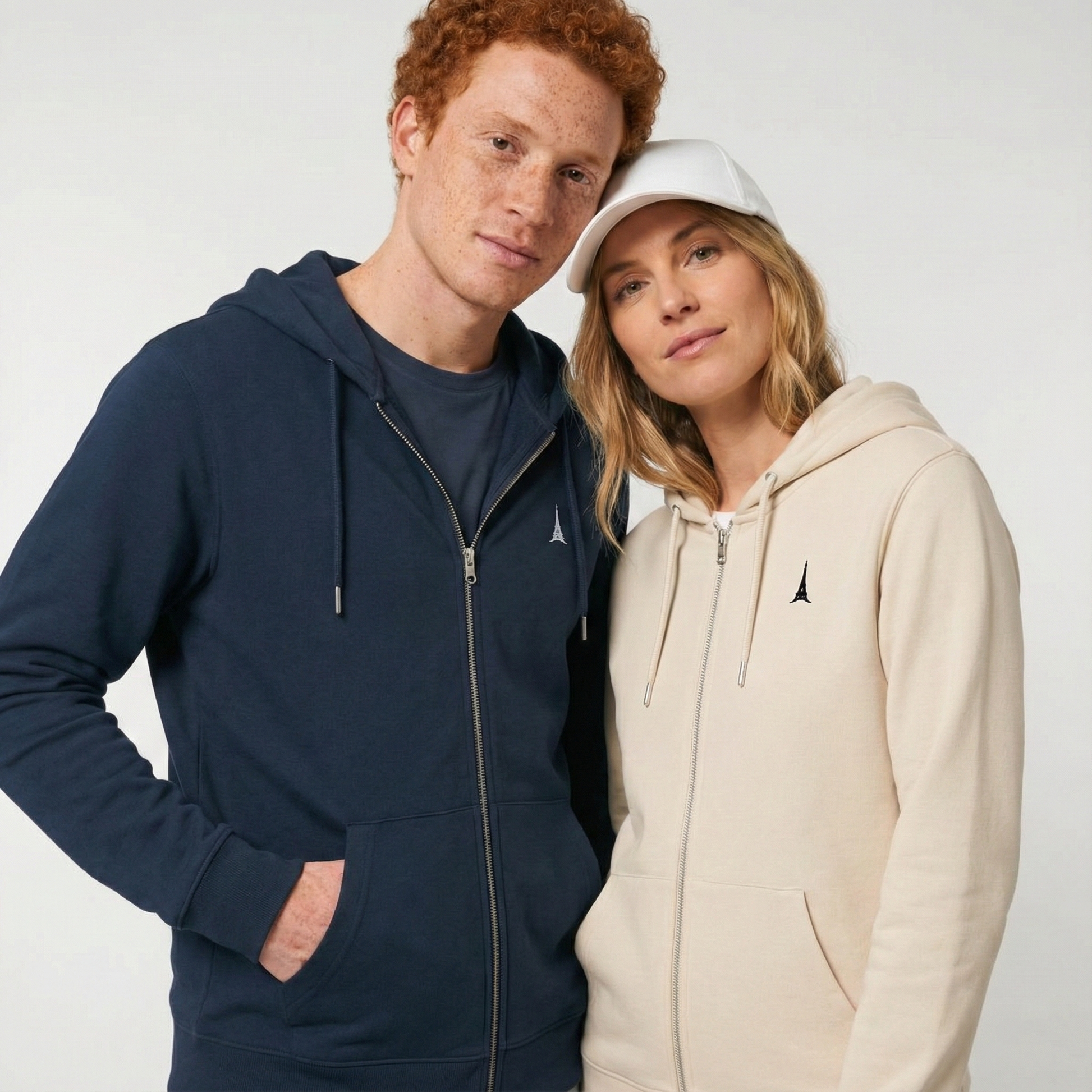 un homme et une femme portent un hoodie zippé unisexe floqué avec un logo représentant les noces de plomb